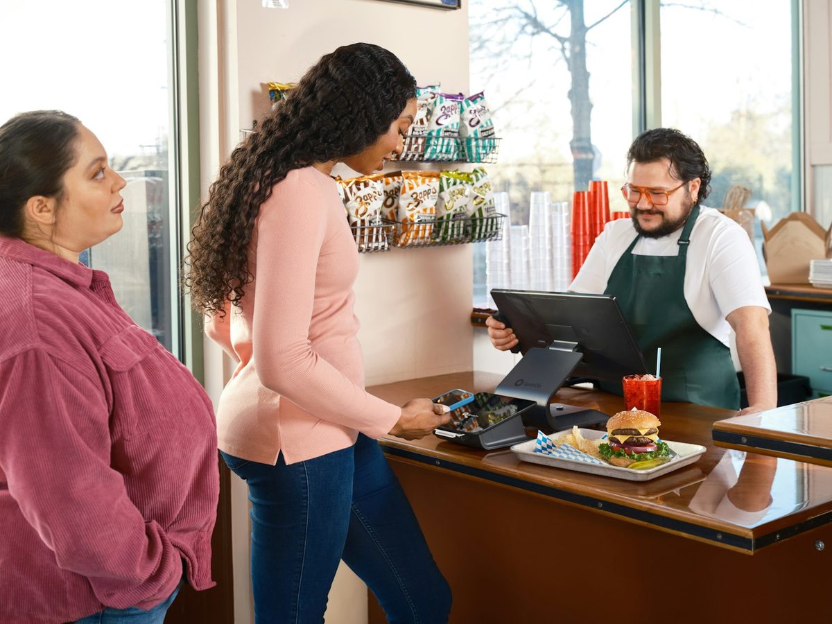 Dos clientas pagando en el mostrador de un local de comida
