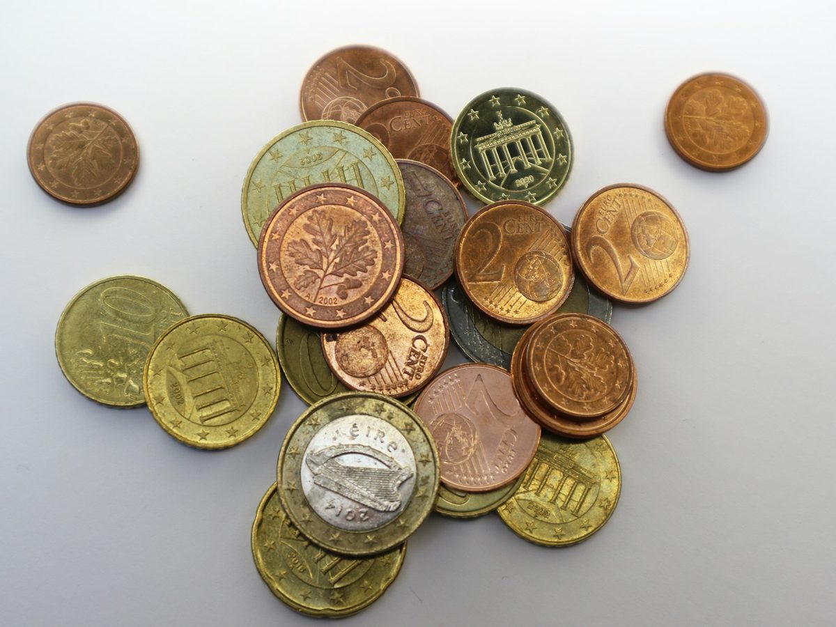 Montón de monedas de euro sobre una mesa blanca