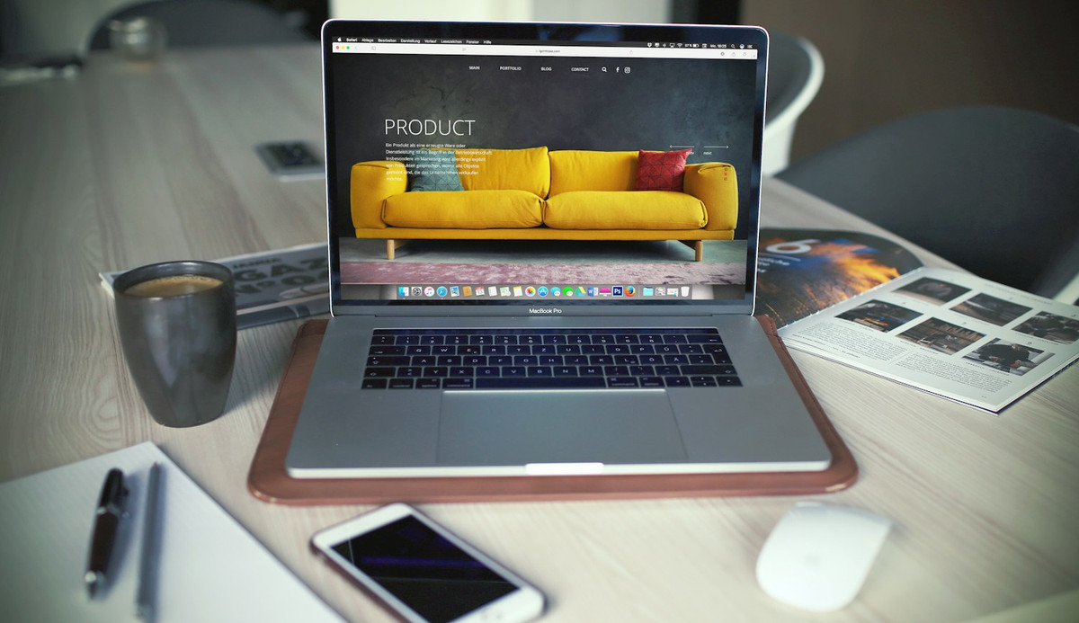 Portátil con una tienda online abierta sobre una mesa de trabajo