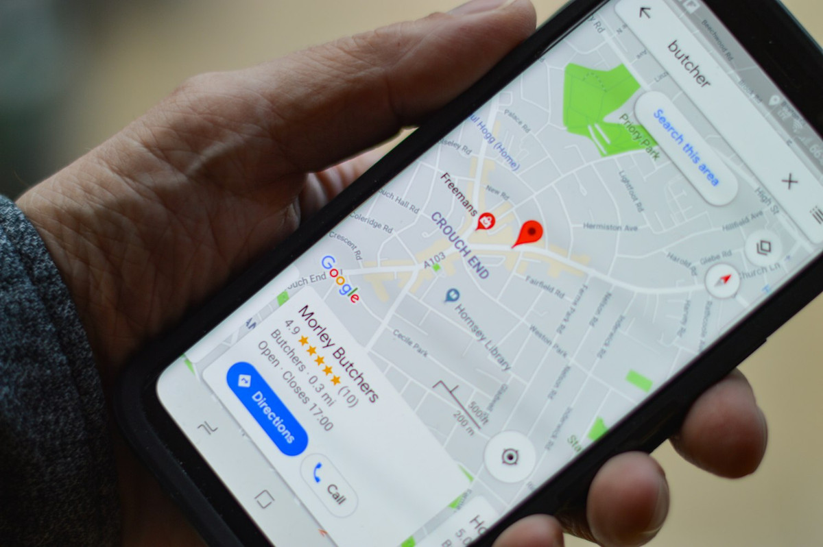 Mano con un móvil que enseña la ficha de un negocio en un mapa