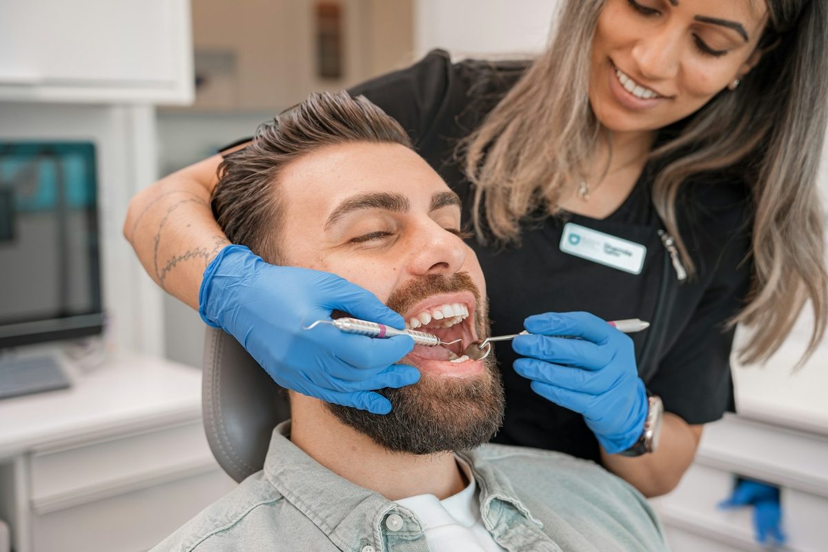 Dentista atendiendo a un paciente que sonríe en el sillón