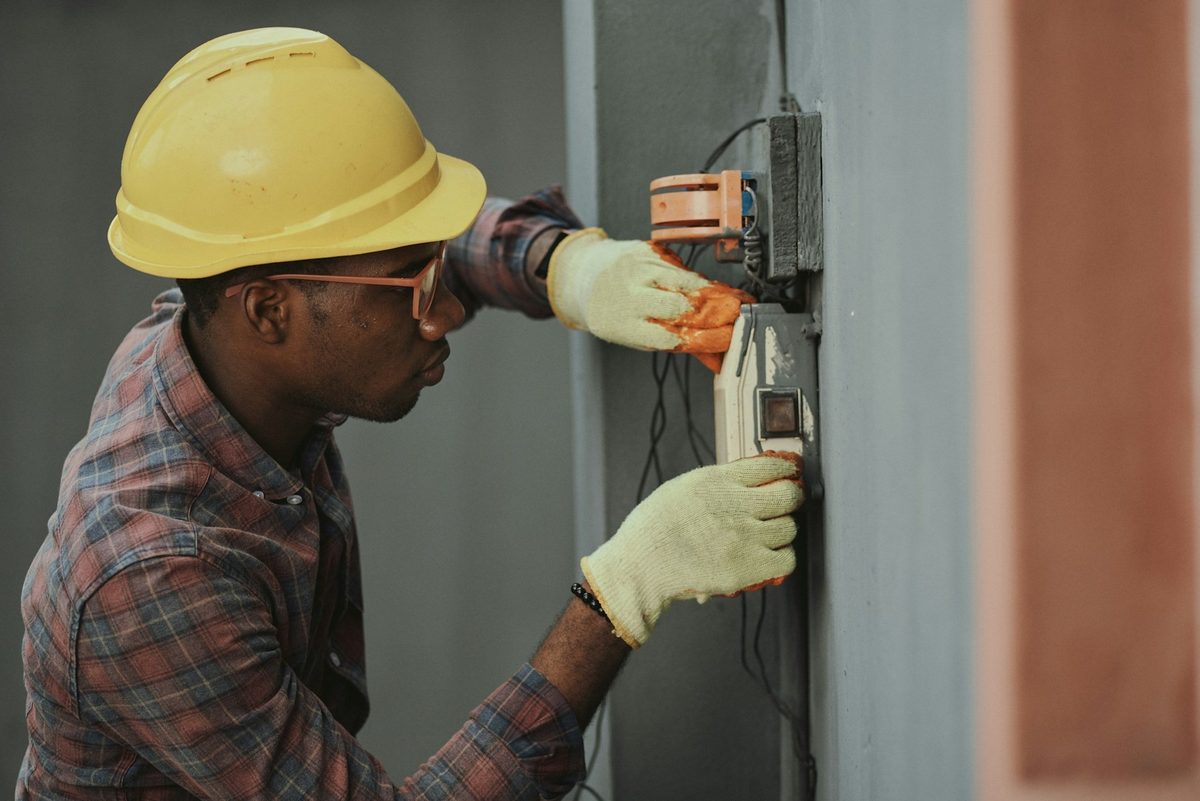 Electricista con casco revisando una instalación