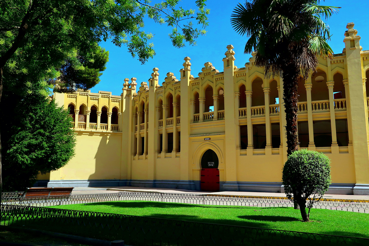 Fachada amarilla de un edificio histórico de Albacete, entre árboles