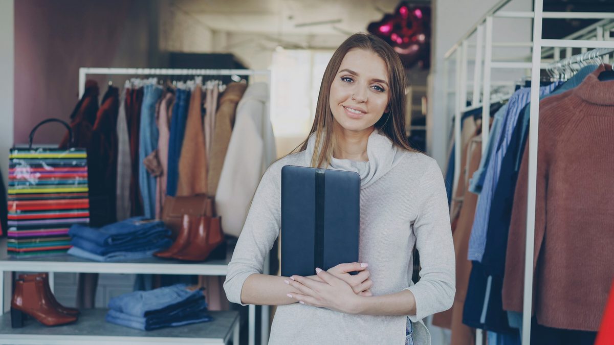 Dueña de una tienda de ropa con una carpeta en la mano
