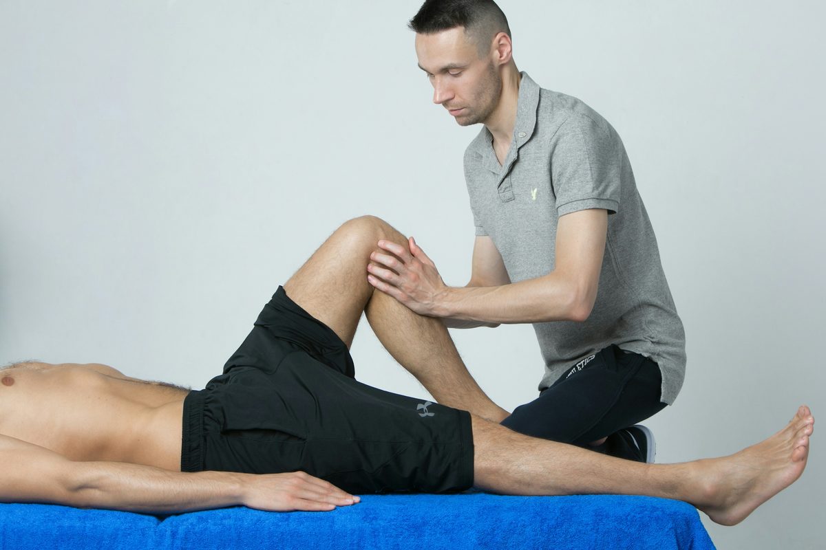 Fisioterapeuta tratando la rodilla de un paciente en la camilla