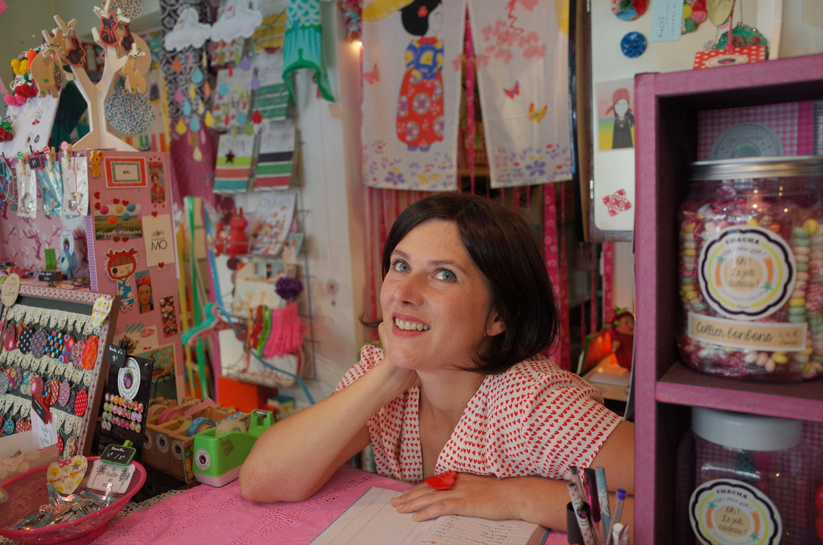 Dueña de una tienda de regalos apoyada en el mostrador