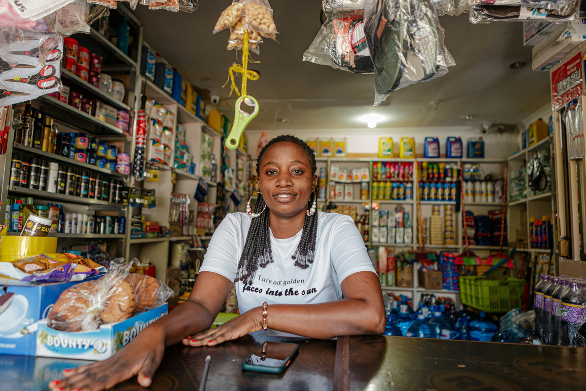 Dueña de una tienda de alimentación sentada entre sus estanterías