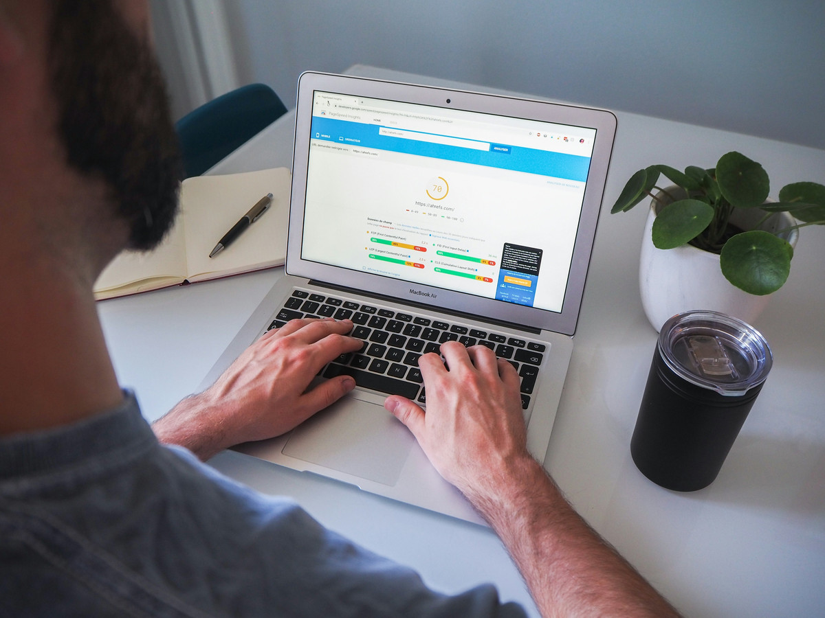 Hombre tecleando en un portátil que enseña la revisión SEO de una web