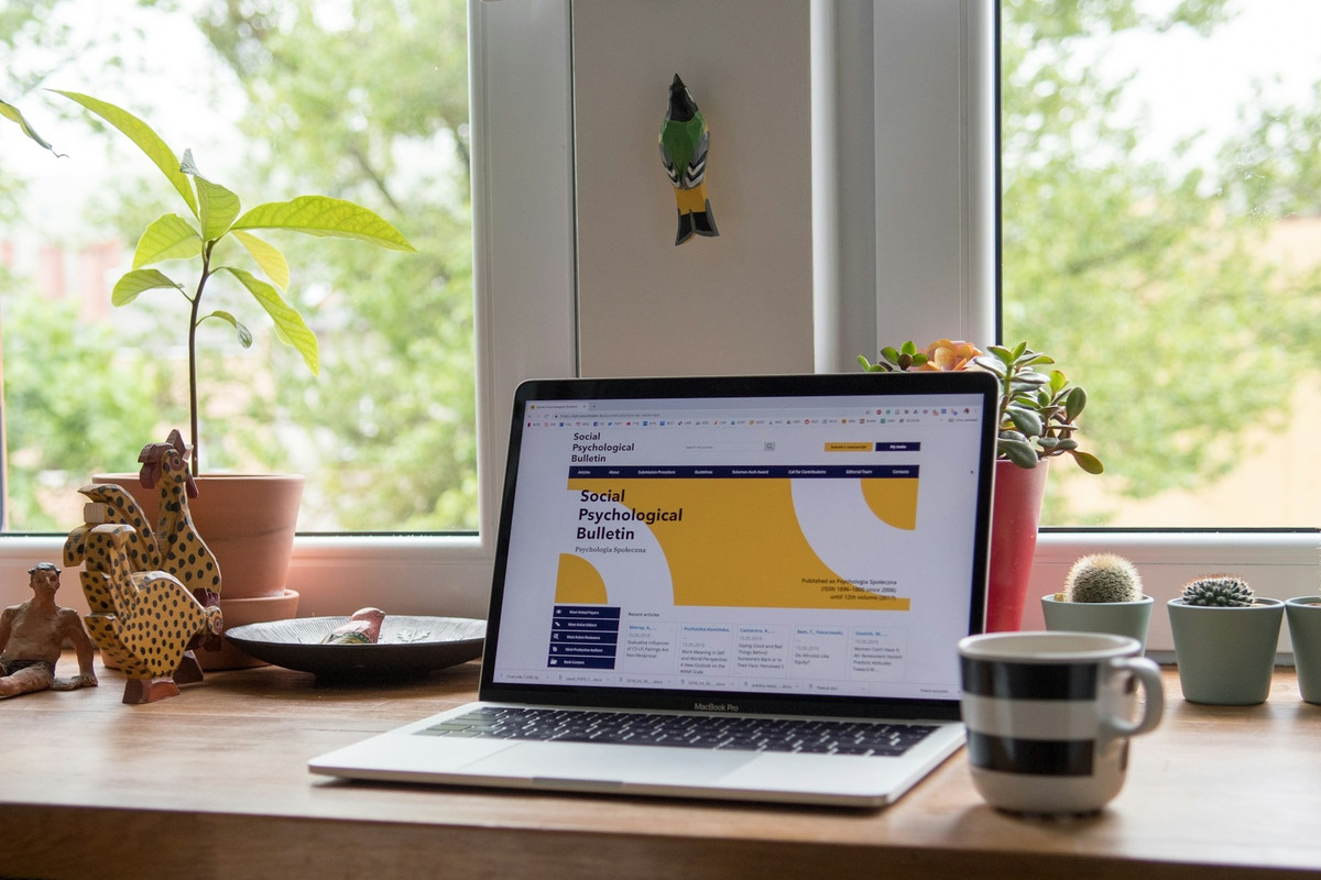 Portátil con una página web abierta en una mesa junto a una ventana