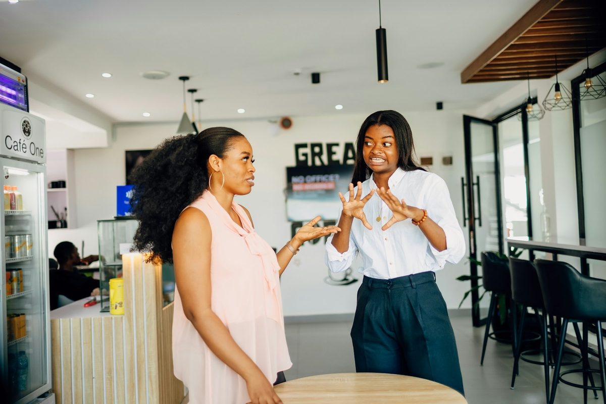 Dos mujeres hablando de pie en una cafetería