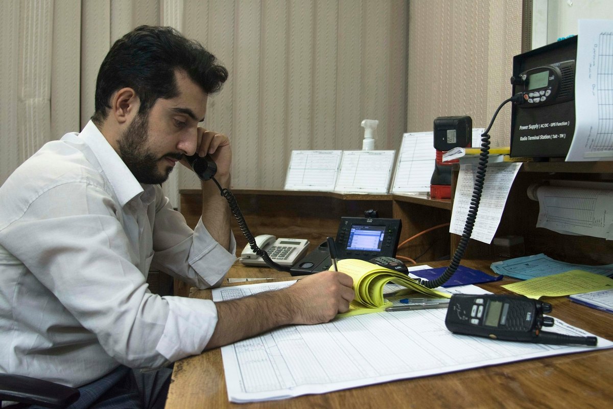 Hombre en su despacho hablando por teléfono mientras toma notas