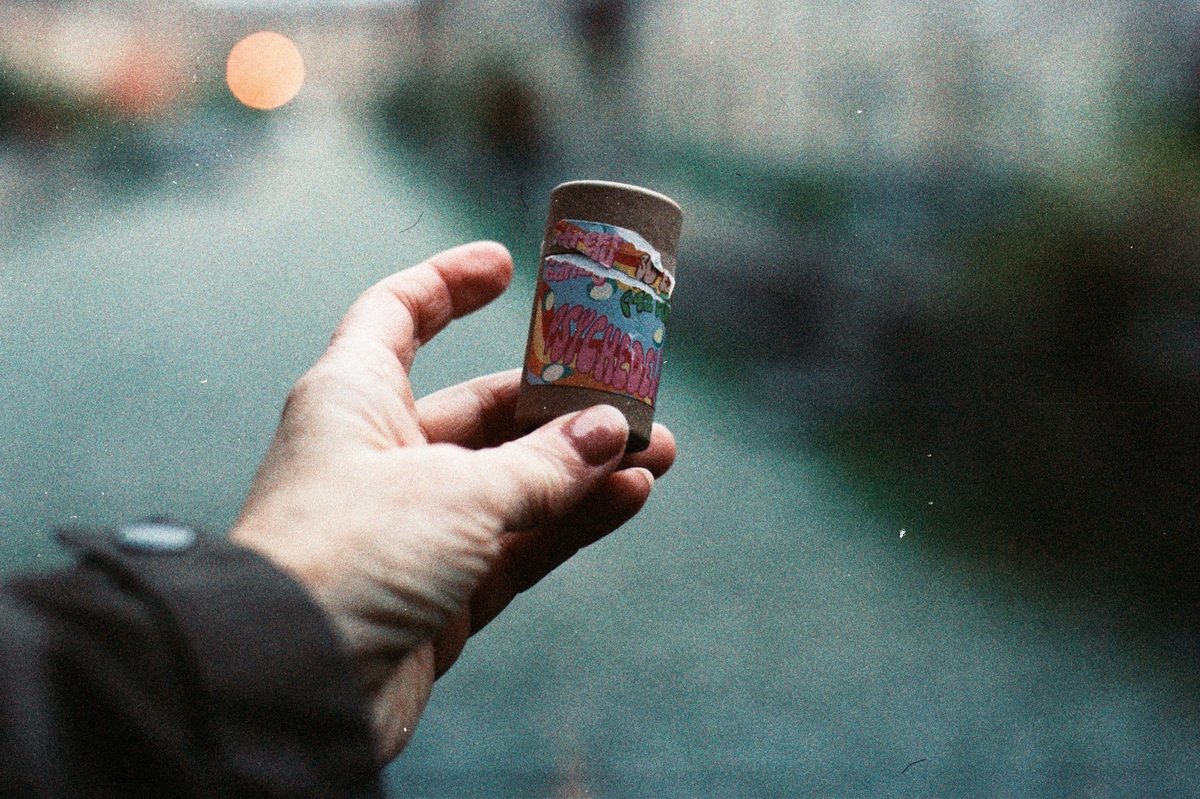 Mano sosteniendo un vaso en la calle