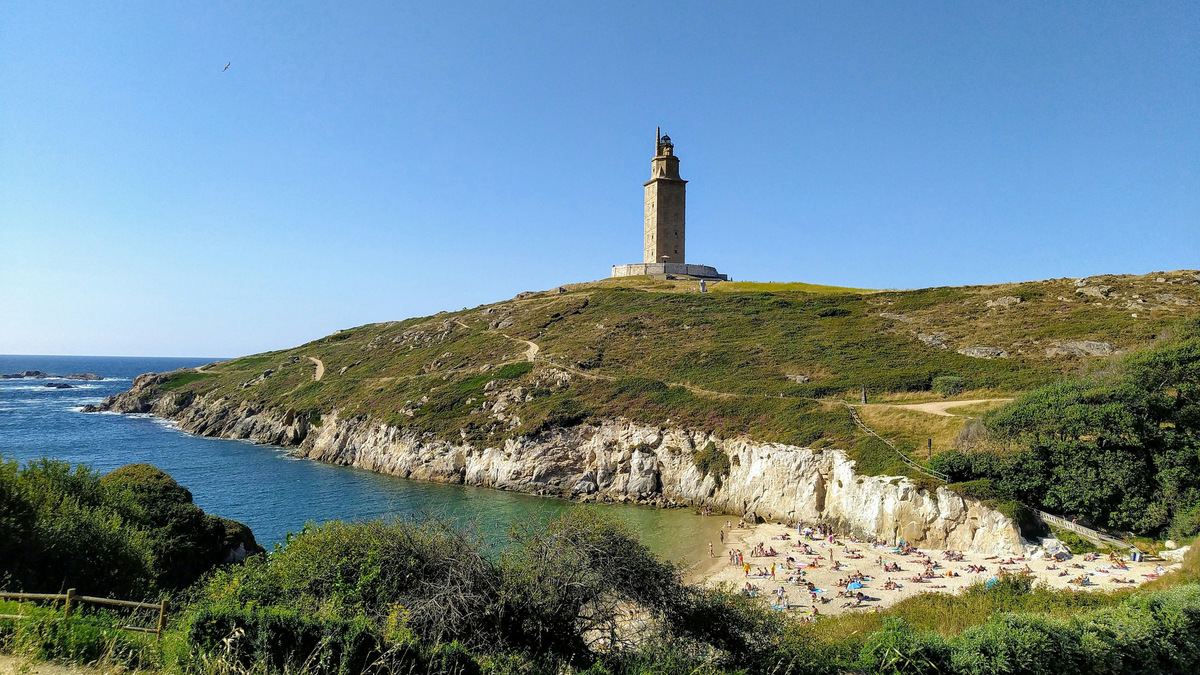 La Torre de Hércules de A Coruña en lo alto de su península, con una cala y el mar a los pies