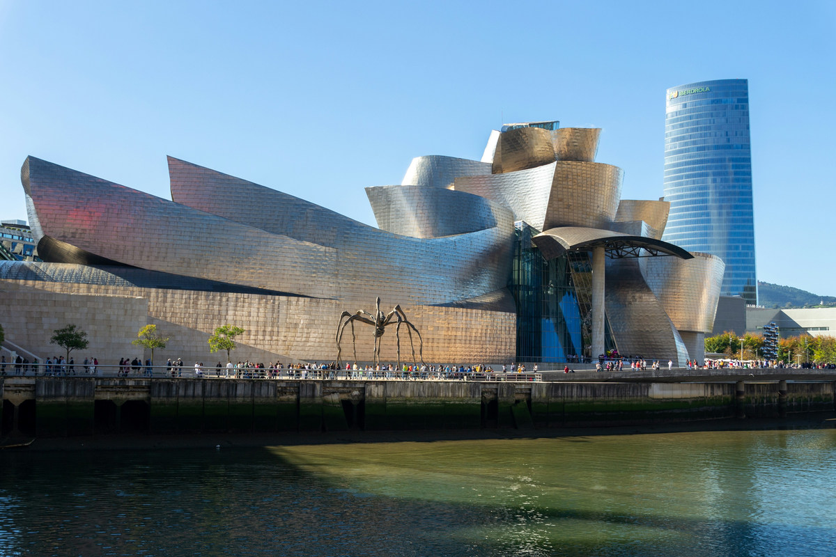 El Museo Guggenheim de Bilbao visto desde la otra orilla de la ría, con la araña de Bourgeois y la Torre Iberdrola detrás
