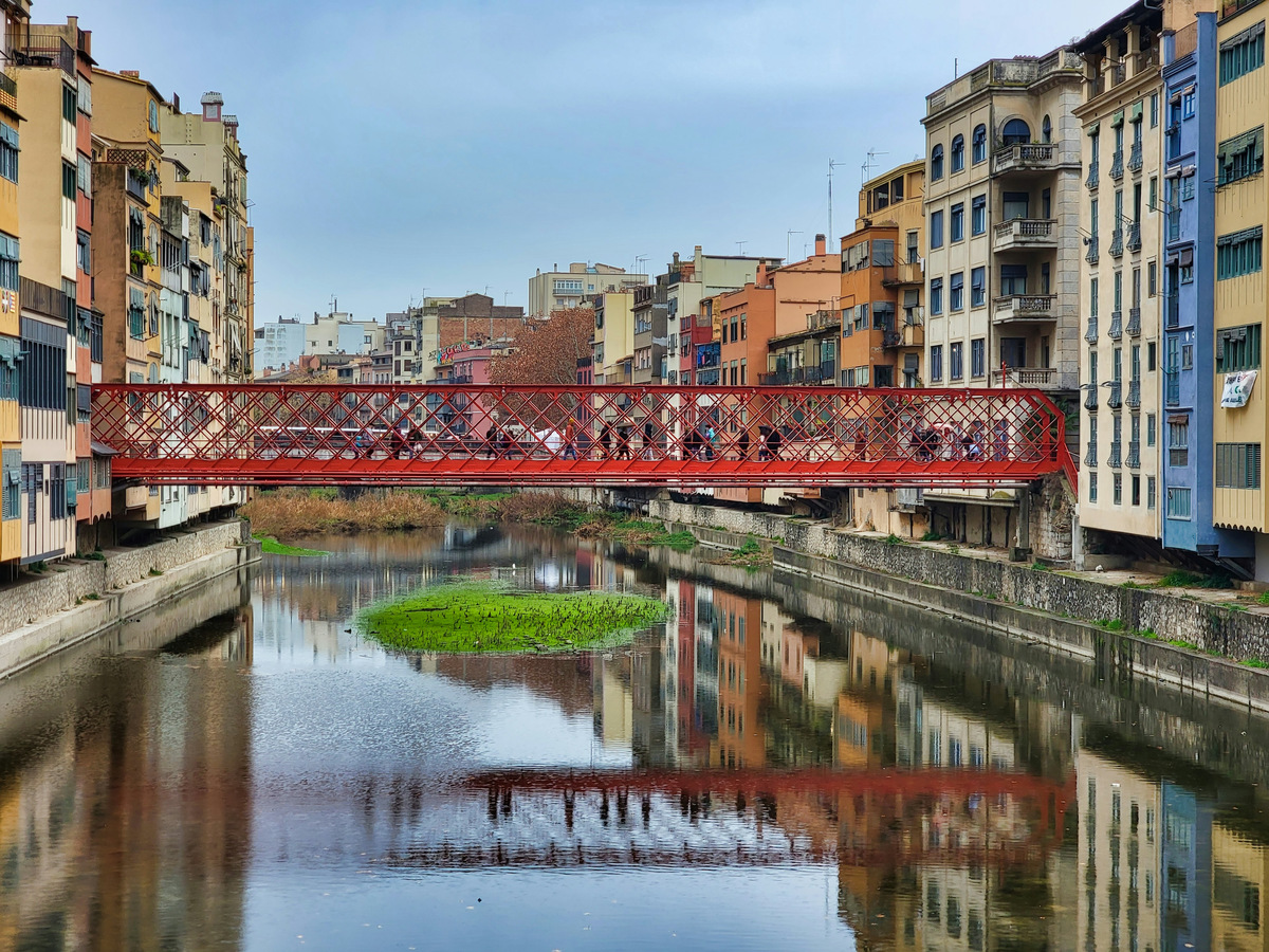 El puente de hierro rojo sobre el río Onyar, en Girona, con las casas de la orilla