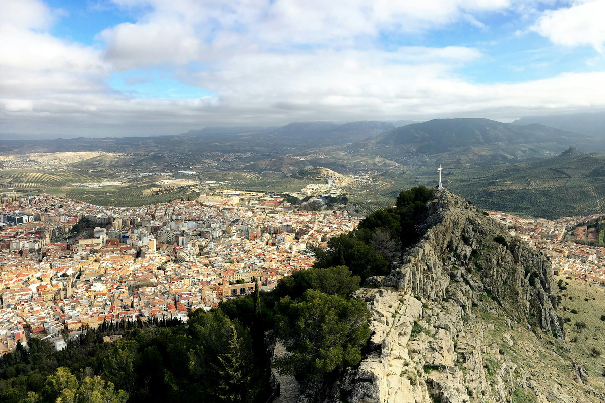 La ciudad de Jaén vista desde el cerro de Santa Catalina, con la cruz sobre la peña y los olivares al fondo