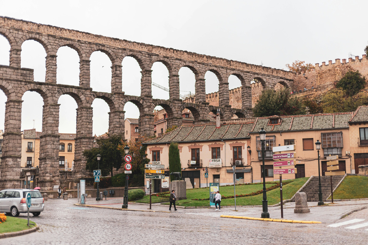 El acueducto de Segovia de lado a lado, con las casas y el jardín de la plaza a sus pies