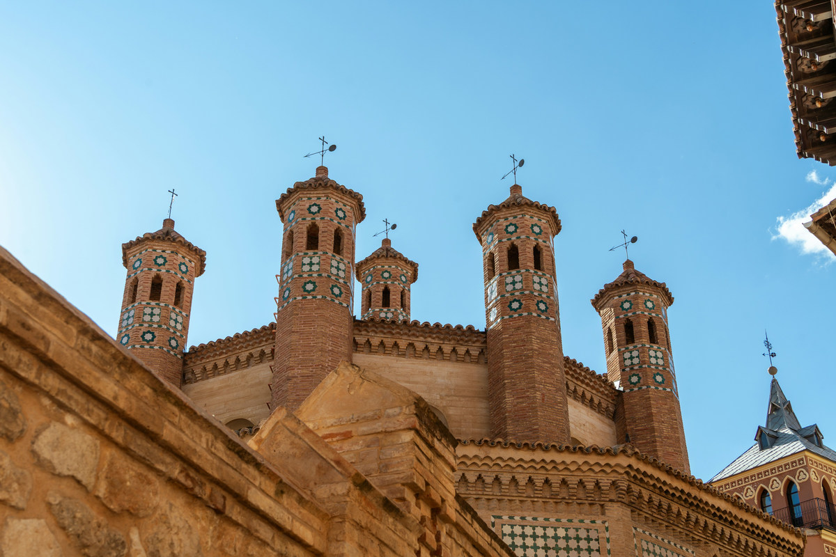 Las torrecillas mudéjares de ladrillo y cerámica de la iglesia de San Pedro de Teruel contra el cielo azul